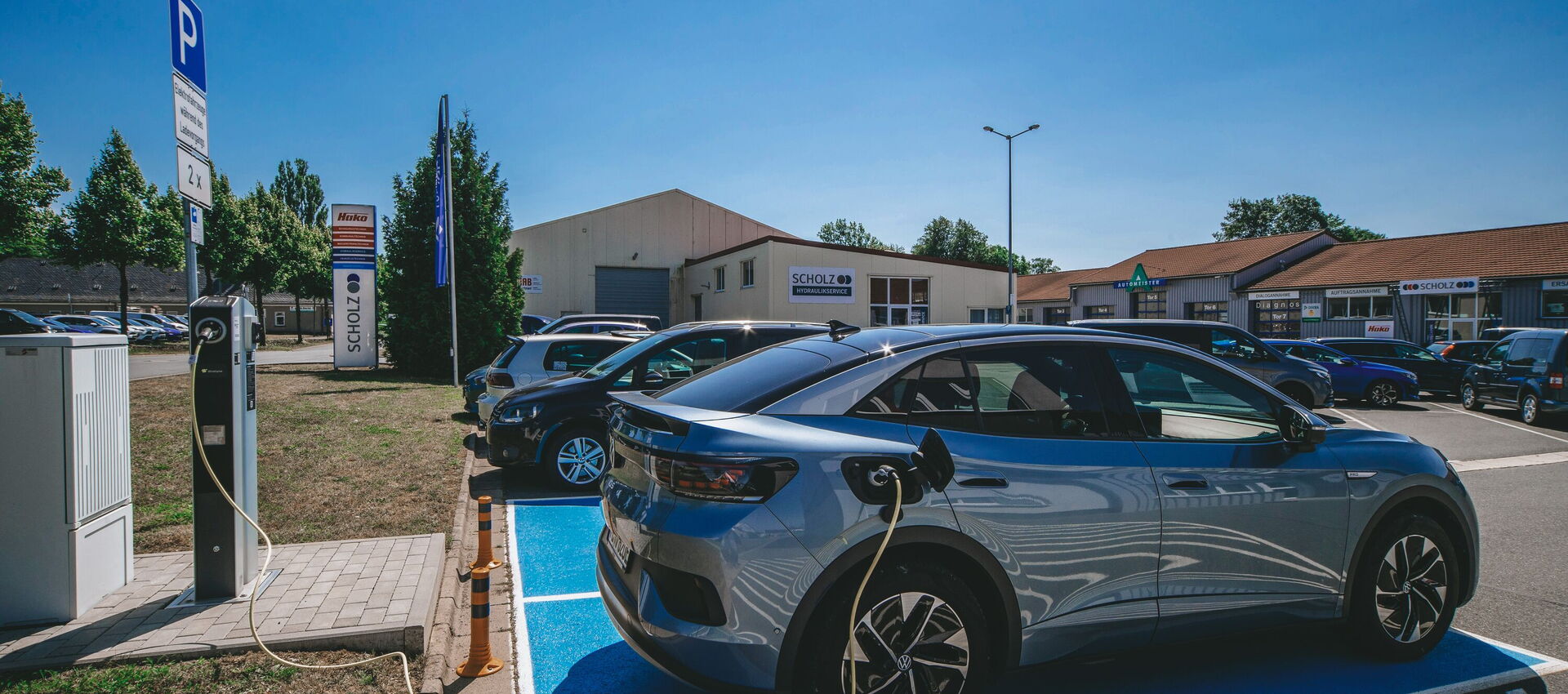 Ein modernes Fahrzeug steckt mit Kabel an einem Ladepunkt.